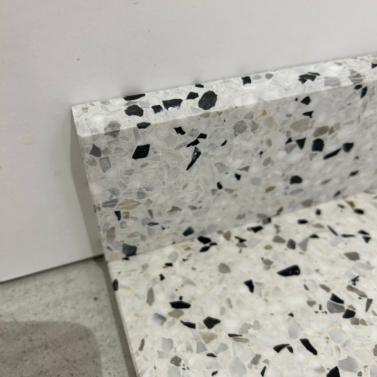 Terrazzo 1910 med sort, hvidt og gråbrunt mix Sokkelkant