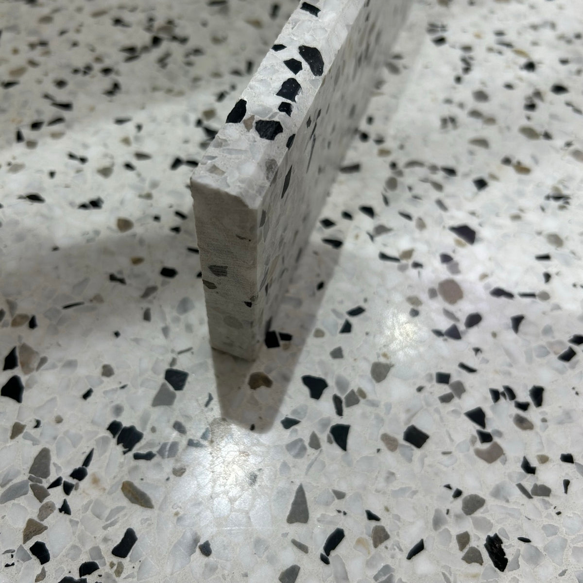 Terrazzo 1910 med sort, hvidt og gråbrunt mix Sokkelkant